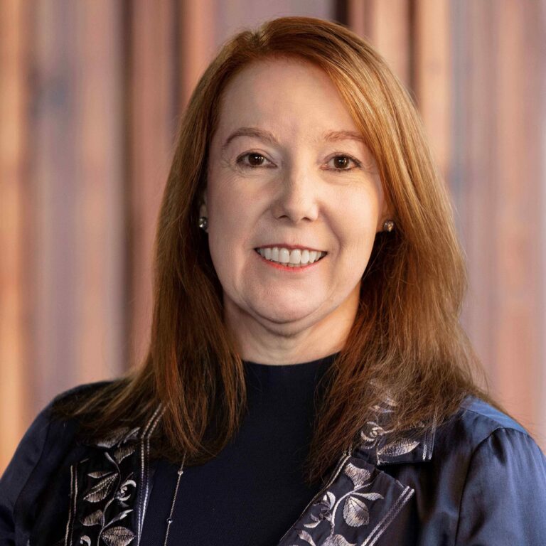 Picture of Susana Schowen wearing a dark blouse.