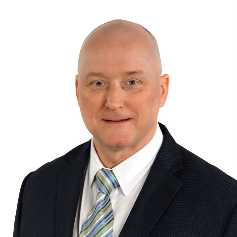 Photo of Lee Rielly wearing a dark suit and tie.